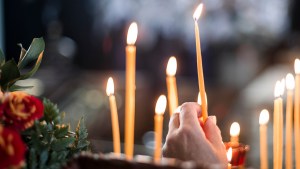 Ręka zapalająca świeczki w cerkwii