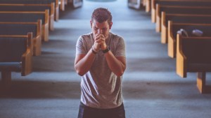 Mężczyzna modli się na środku kościoła