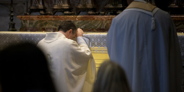 Ksiądz modli się przy ołtarzu