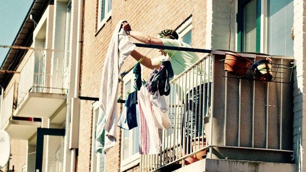 Kobieta stojąca na balkonie i wiszące pranie