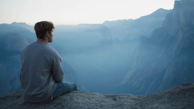 Mężczyzna medytuje w górach