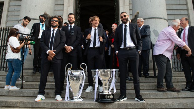Piłkarze Realu Madryt z trofeum za zwycięstwo w Lidze Mistrzów stoją przed katedrą La Almudena w Madrycie