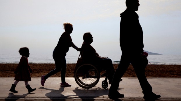 rodzina z niepełnosprawnym członkiem na promenadzie