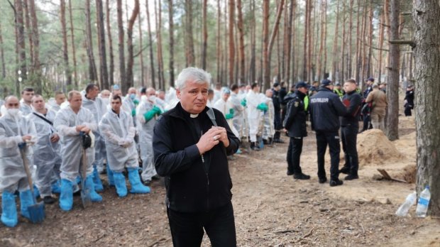 kardynał Konrad Krajewski nad grobami w Iziumie