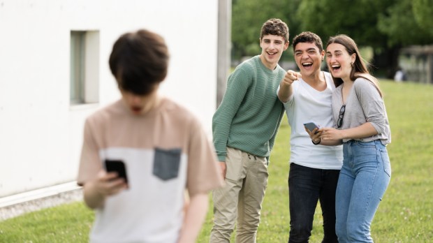 grupa nastolatków naśmiewa się z kolegi