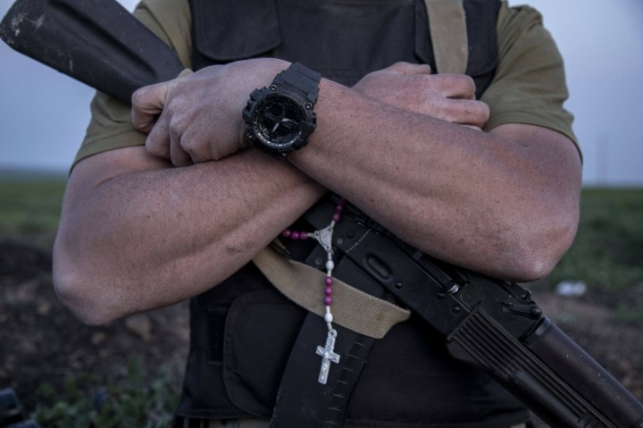 ukraiński żołnierz z różańcem przymocowanym do broni