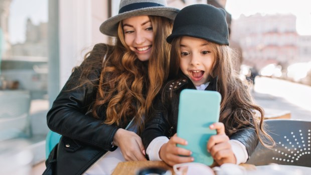 Młoda mama i jej mała córeczka robią sobie selfie smartfonem