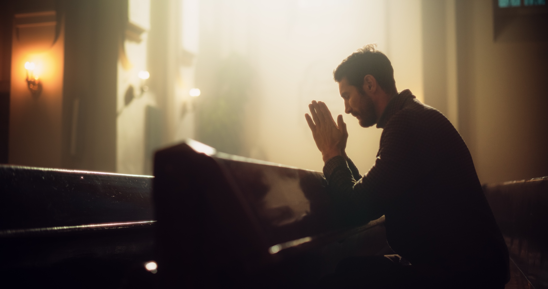 mężczyzna modli się w kościelnej ławce