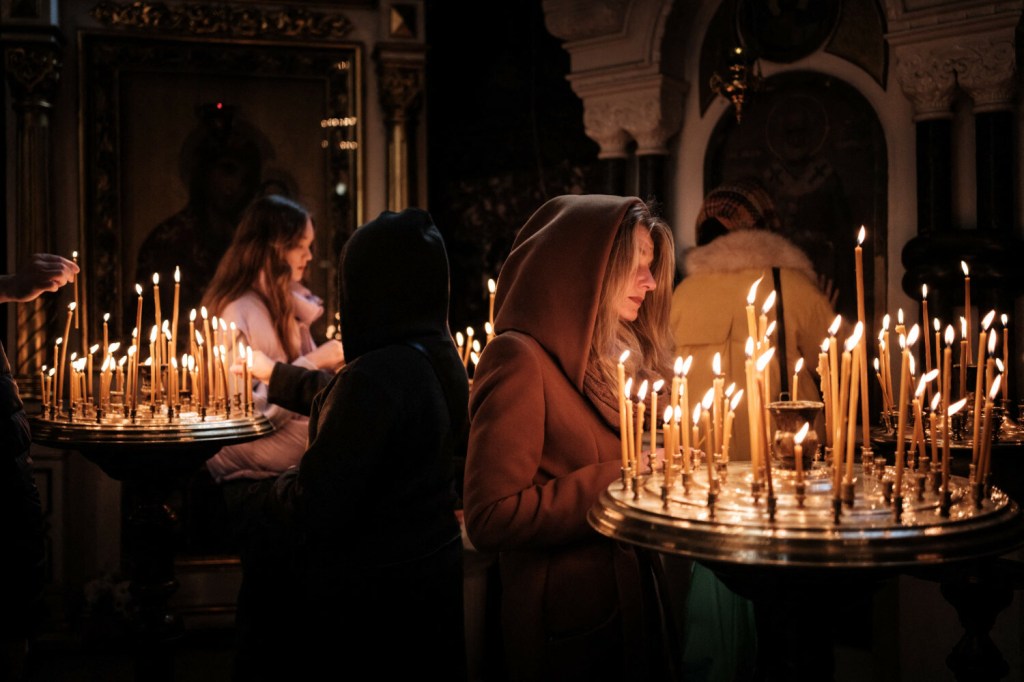 Ukraińskie kobiety zapalają świece i modlą się w katedrze w Kijowie