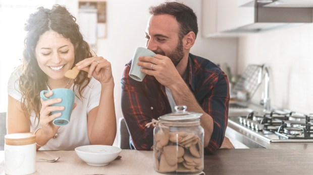małżeństwo rozmawia w kuchni popijając kawę i ciesząc się byciem razem