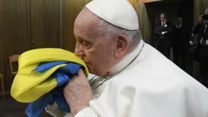 Papież Franciszek całuje ukraińską flagę podczas pokazu filmu dokumentalnego na temat wojny na Ukrainie