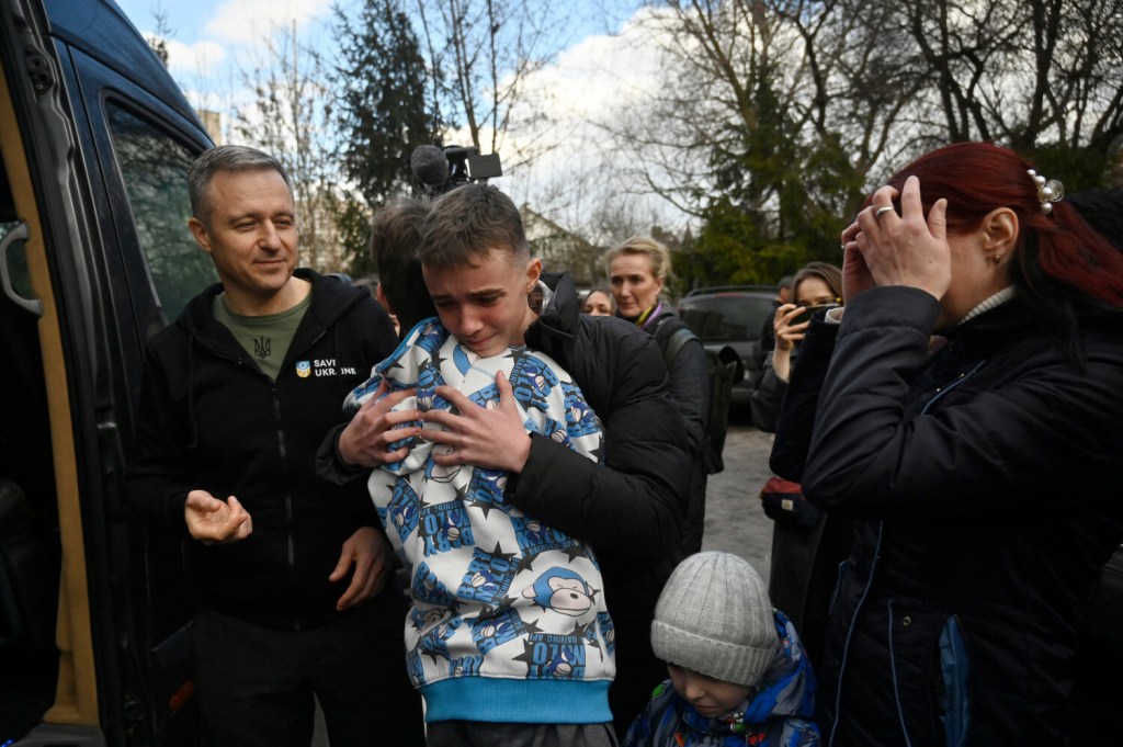 Inessa (z prawej) wita się ze swoim synem Witalijem, który właśnie wraz z kilkanaściorgiem innych dzieci dotarł do Kijowa autobusem z terytorium okupowanego przez Rosję (22 marca 2023)