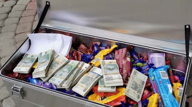 Skrzynia wypełniona słodyczami i pieniędzmi pod domem dziecka