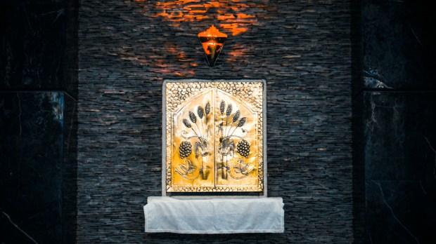 Złote tabernakulum na ciemnej ścianie