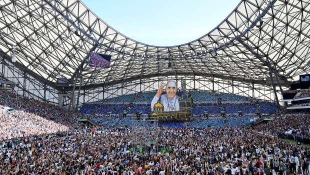 Supporters of the Olympique de Marseille football club hold up a huge banner of Pope Francis as he arrives to celebrate mass at the Velodrome stadium in the southern port city of Marseille