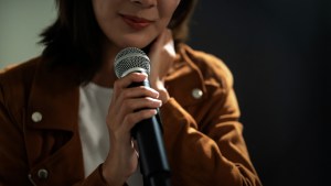 Kobieta mówi przez mikrofon swoje świadectwo